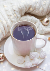 Obraz na płótnie Canvas Winter, Christmas, New Year decorations composition, concept, background. White Mug, cup of tea, coffee, steam, meringue, knitted plaid. Christmas lights. Christmas mood morning. Christmas card.