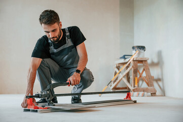 Tile cutting process. The man is making repairs in the apartment