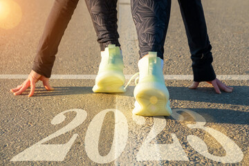 Female legs of runner at starting line on road close-up. Start running into new year 2023,...