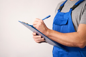 Man worker in blue uniform holding paper clipboard