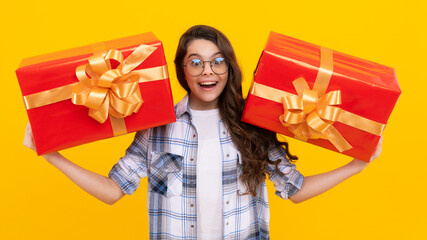 surprised teen kid in glasses with present. studio shot of teen kid hold present. teen kid