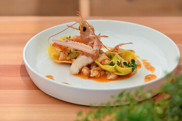 Ravioli stuffed with ricotta and truffle, sautéed with butter, sage and scampi