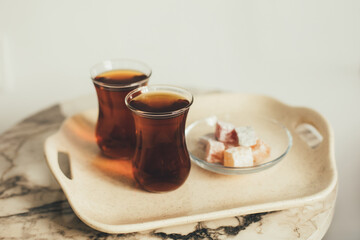 Turkish tea and dessert on a tray on white background.