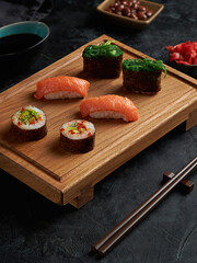 wooden board and chopsticks with japanese rolls and sushi.