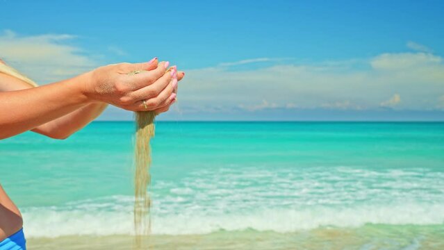 Sand Grains Run Through Female Hands. Woman Holding and Releasing Sand Through Fingers. Irreversible Flow of Time. Loss and Inconvertibility.