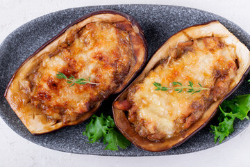 Stuffed eggplant halves with roasted vegetables, champignons and cheese. Hot vegetarian meal. Top view