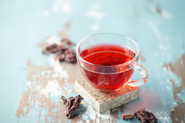 Red tea carcade in glasses and dried hibiscus flowers.