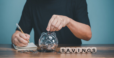 Family financial savings planning, Man hand holding piggy bank on wood table, saving money wealth and financial concept, Business, finance, investment, Financial planning.