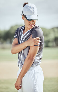 Baseball player, arm injury and pain during sports training, fitness exercise and athlete practice outdoor on field. Injured man massage muscle area for fibromyalgia, orthopedic or softball accident