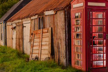 Telephone box with rustic huts