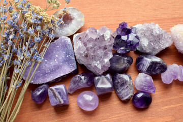 Beautiful amethyst stones and amethyst druze with dry lavender bouquet on wooden background. Magic...
