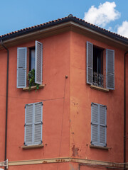 Bologna house window decorated with flowers and wooden shutters - Bologna, Italy