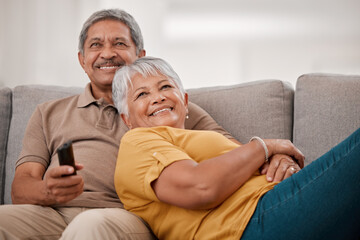 Happy senior couple, love and watching tv relax together on living room sofa at family home. Elderly married man and woman, chill and watch television on couch bonding, laughing and smile at movie