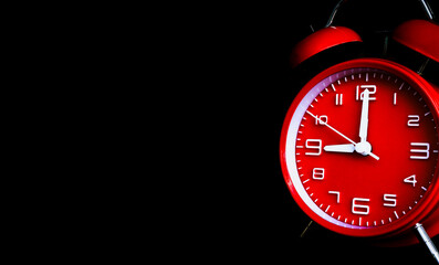 remote image of The red alarm clock is set to 9:00 a.m. on a dark background