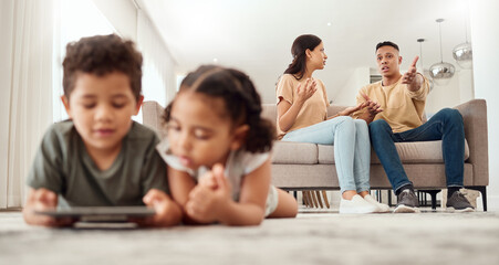 Mother, father and disagreement on living room sofa while children are playing with tablet on the floor at home. Mama and dad fighting, argue or conflict in difficult situation on couch in dispute