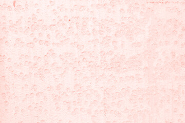 Pink wall with craters like on the moon. Beautiful gentle background for the inscription.