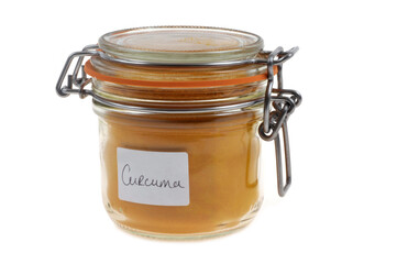Bocal de curcuma en gros plan sur fond blanc