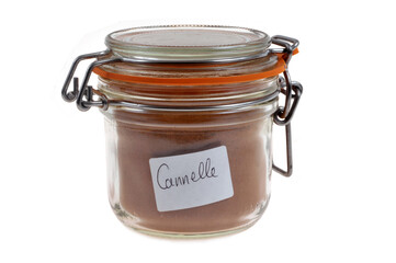 Bocal de cannelle en poudre en gros plan sur fond blanc