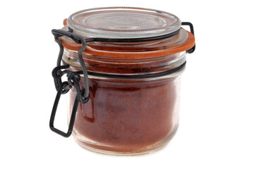 Bocal de paprika en poudre en gros plan sur fond blanc