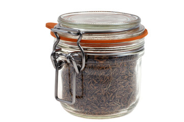 Bocal de graines de cumin en gros plan sur fond blanc