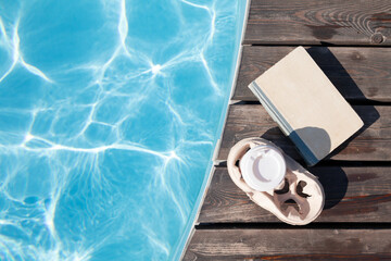 Fototapeta na wymiar Book and coffee near swimming pool