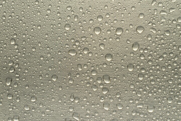 Raindrops on the chrome-plated metal surface. Rain on a metallic silver background.