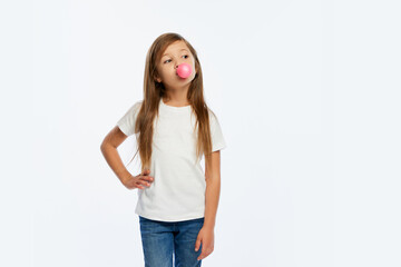 Bubble gum. Portrait of elementary school age girl, pupil in casual style clothes isolated over white background. Concept of children emotions, fashion, fun