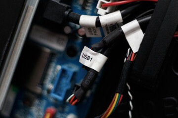 Fototapeta na wymiar Close up on electronic components of a modern gaming computer. Colored cables are visible. Focus on a white label indicating 