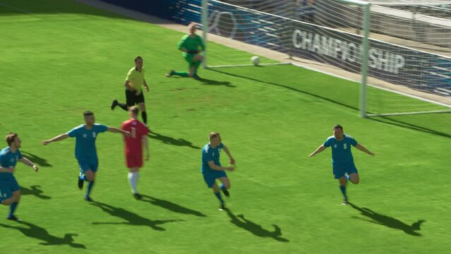Football Championship: Blue Team Forward Shots Penalty, Kicks the Ball and Scores the Goal. Goalkeeper Fails to Catch Ball. Winning the Match and Game, Players Celebrate Tournament Victory