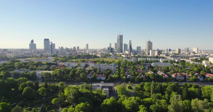 Pole Mokotowskie Warsaw Park field with lake and city skyscrapers in the background. Aerial view of the city park with green trees. Summer season.
