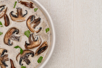 Closeup of a bowl of homemade mushroom soup on a white farm table