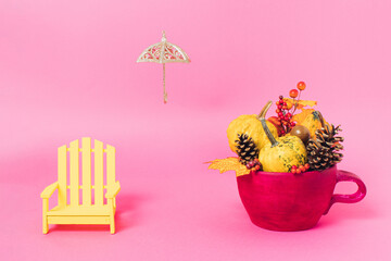 Beach chair, umbrella and pumpkin in pot minimal summer transition to fall season on vibrant pink background. Creative colorful autumn layout. Natural season changing concept.