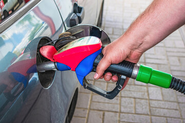 The driver fills up expensive gasoline in the fuel tank of the car