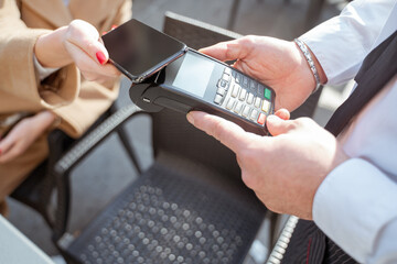 A woman paying by gpay in a street cafe