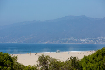 Fototapeta na wymiar Malibu Beach View with Ocean, Village, Sand, and Mountain Zoomed by Telephoto Lens on Sunny Bright Day