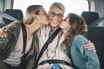 Family, children and road trip with a girl, mother and grandmother kissing in the backset of a car....