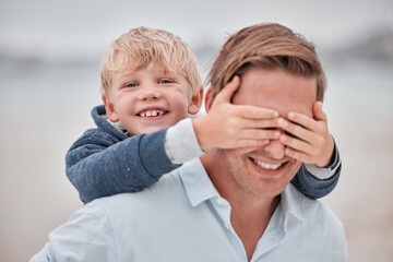 Family, face and father and son at a beach with hands covering dad eyes for surprise, guess and game. Travel, happy family and child hand on man eye while walking, laughing and bonding on ocean trip