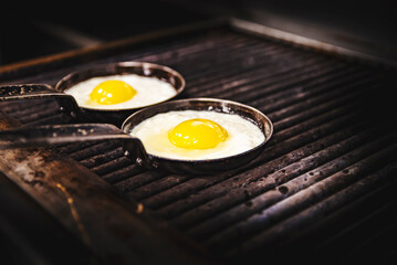 cooking Eggs in pan on grill in kitchen