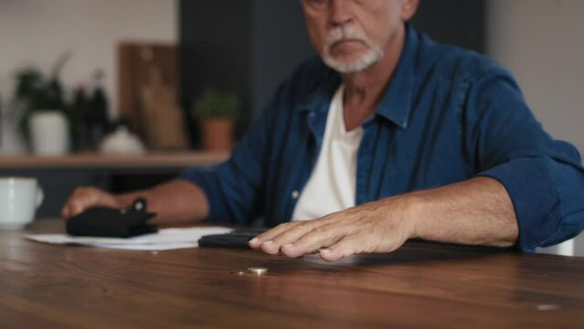 Caucasian senior man counting home budget using calculator. Shot with RED helium camera in 8K. 