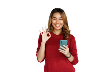 Naklejka premium Using mobile, Excited young brunette pretty asian woman isolated on white background, red sweater.