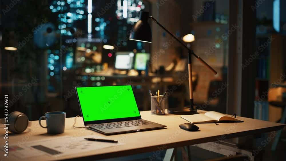 Poster laptop computer standing on a desk with a green screen chromakey mock up display in modern creative 