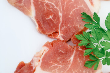 Raw Pork Slice in White Round Plate decorated with parsley. Fresh raw pork.