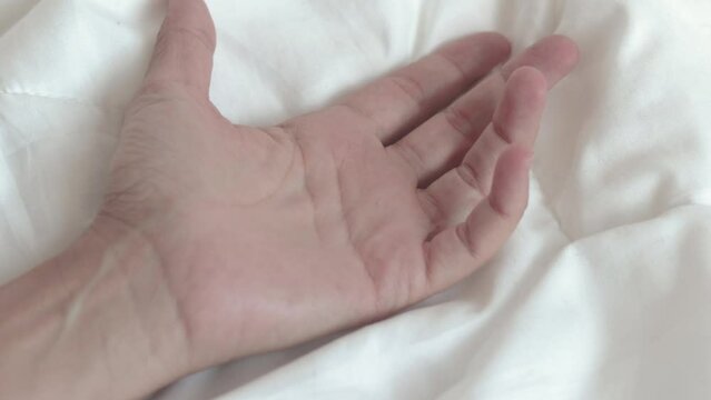 woman hand hold outstretched on white blanket morning bedroom interior.girl palm hold tight the cover.calm relaxed morning or sexual relationship concept 4k real time open palm move fingers young 