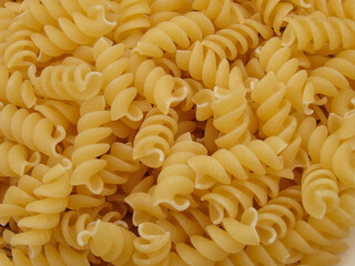 Raw spiral pasta background. Background of pasta closeup. Raw food background or texture close up. Spiral uncooked macaroni wallpaper