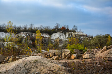 Flooded granite quarry White rocks near village Aktove, Ukraine. Colorful leaves of trees in the autumn landscape, colors of leaf-fall. Granite quarry and chalk rocks near the Mertvod river.