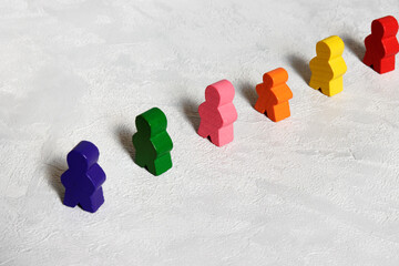 Wooden colorful human-shape figures standing in waiting line.