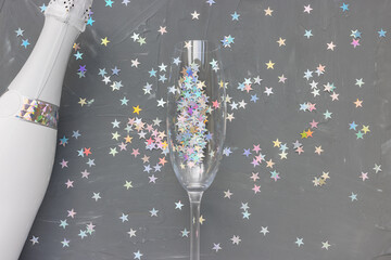 Champagne bottle and glass on black festive background. New Year party