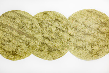 Mexican spinach flavored wheat tortilla wraps on white background