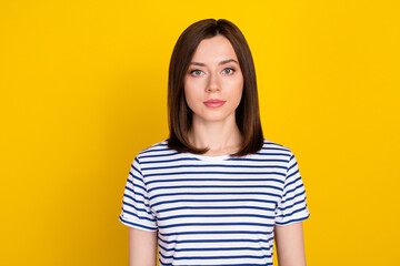 Fototapeta premium Photo of young gorgeous adorable girl with bob hairstyle dressed striped t-shirt looking at camera isolated on yellow color background