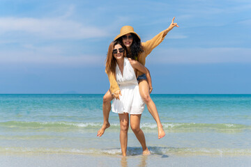 Fototapeta premium LGBTQ lesbian couple on the beach The couple went to the sea on vacation together happily.